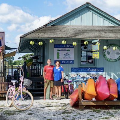 Mary and Bill Burnham, owners of Burnham Guides, stand in front of their paddling outfitter in Onancock