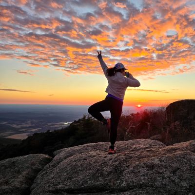 Alejandra Villanueva of Girls Who Hike Virginia hula hoops on Old Rag Mountain summit at sunrise.