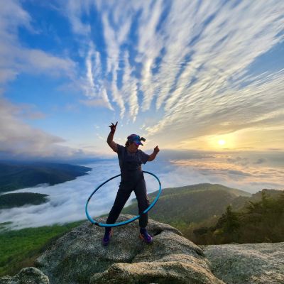 Alejandra Villanueva of Girls Who Hike Virginia hula hoops on Old Rag Mountain summit at sunrise.