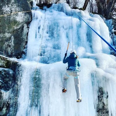 Woman ice climbing on a frozen waterfall in Virginia's Blue Ridge Mountains.