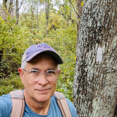 Author and Historian, Mills Kelly, poses by a white blaze on a tree marking the Appalachian Trail