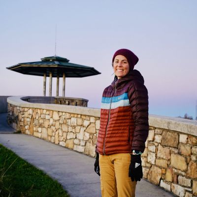 Norton Tourism Director and podcast guest, Katie Dunn, stands at High Knob Observation Tower in Norton at sunset.